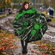 A woman standing outdoors in the rain holding up a large umbrella. The umbrella features a bold graphic print of a green and black motorcycle racer.