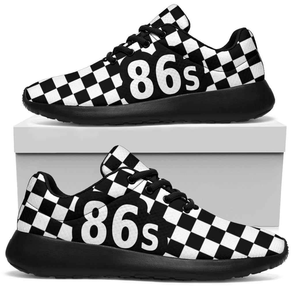 A pair of black and white checkerboard sneakers with large white '86s' text on the side, displayed on and above a white shoebox against a white background.