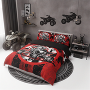 A bed dressed in a red, black, and white racing-themed bedding set, styled in a modern gray bedroom with ATV decals on the wall, a toy ATV on the floor, and a matching round rug.