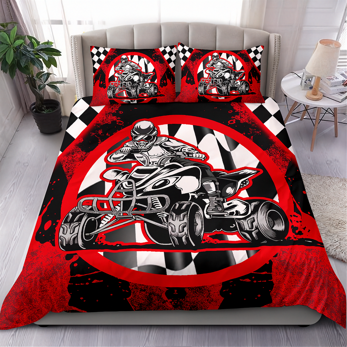 A bedding set displayed on a bed in a styled bedroom, featuring a red, black, and white quad bike racing graphic on the comforter and matching pillowcases with a checkered pattern.
