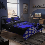 Bedroom with blue and black bedding set, desk, and ATV-themed decor.