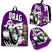 An adult woman and an 8 to 12-year-old child walking side-by-side through an asphalt drag strip paddock with faint burnout smoke in the distance, both wearing matching custom purple drag racing backpacks viewed from behind.