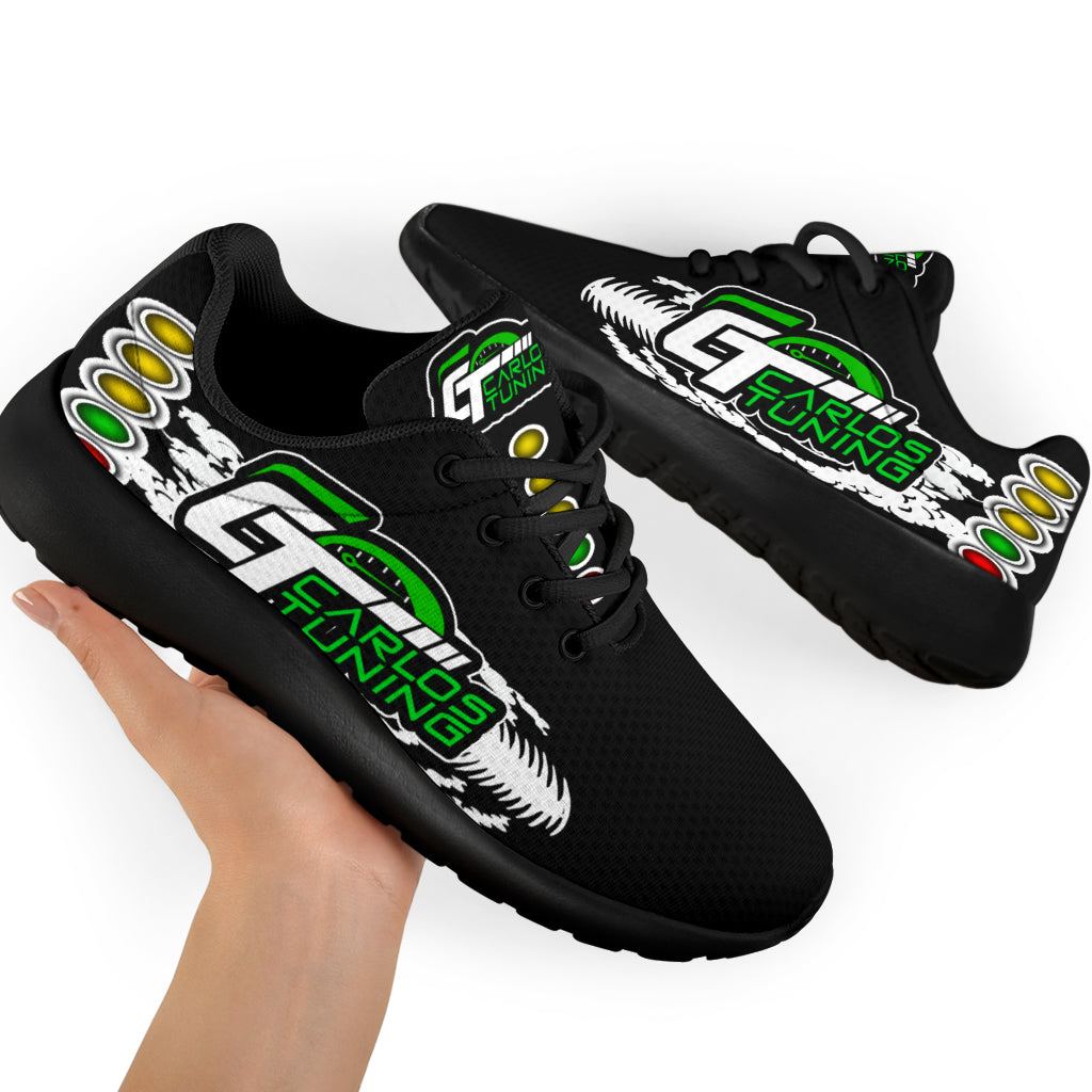 Hand holding a black personalized drag racing sneaker, showing the sample team logo, white tire tracks, and starting-light artwork.