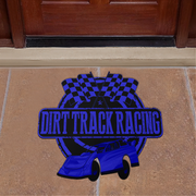A die-cut vinyl doormat featuring a blue and black 'Dirt Track Racing' design with a race car and checkered flags, displayed on a tan stone tile floor in front of a dark wood door.