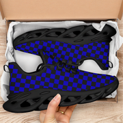 Black and blue checkered shoes in an open cardboard box on a wooden surface.