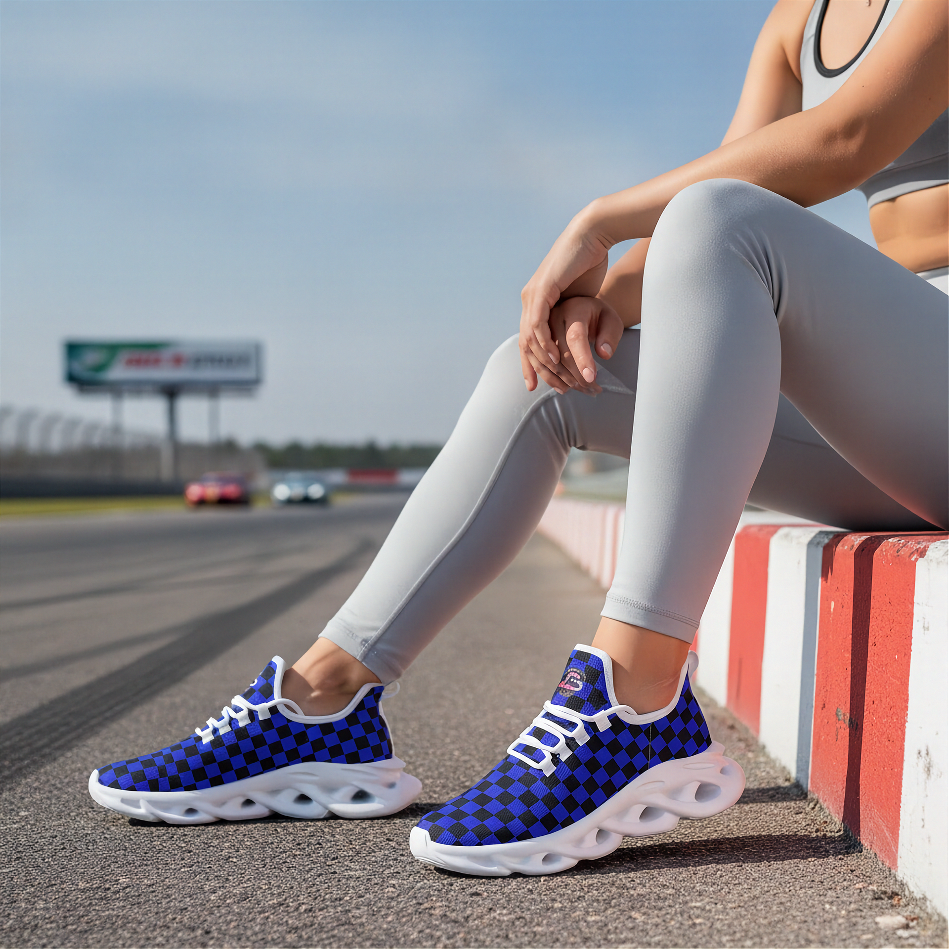 Person wearing blue checkered sneakers sitting on a race track.