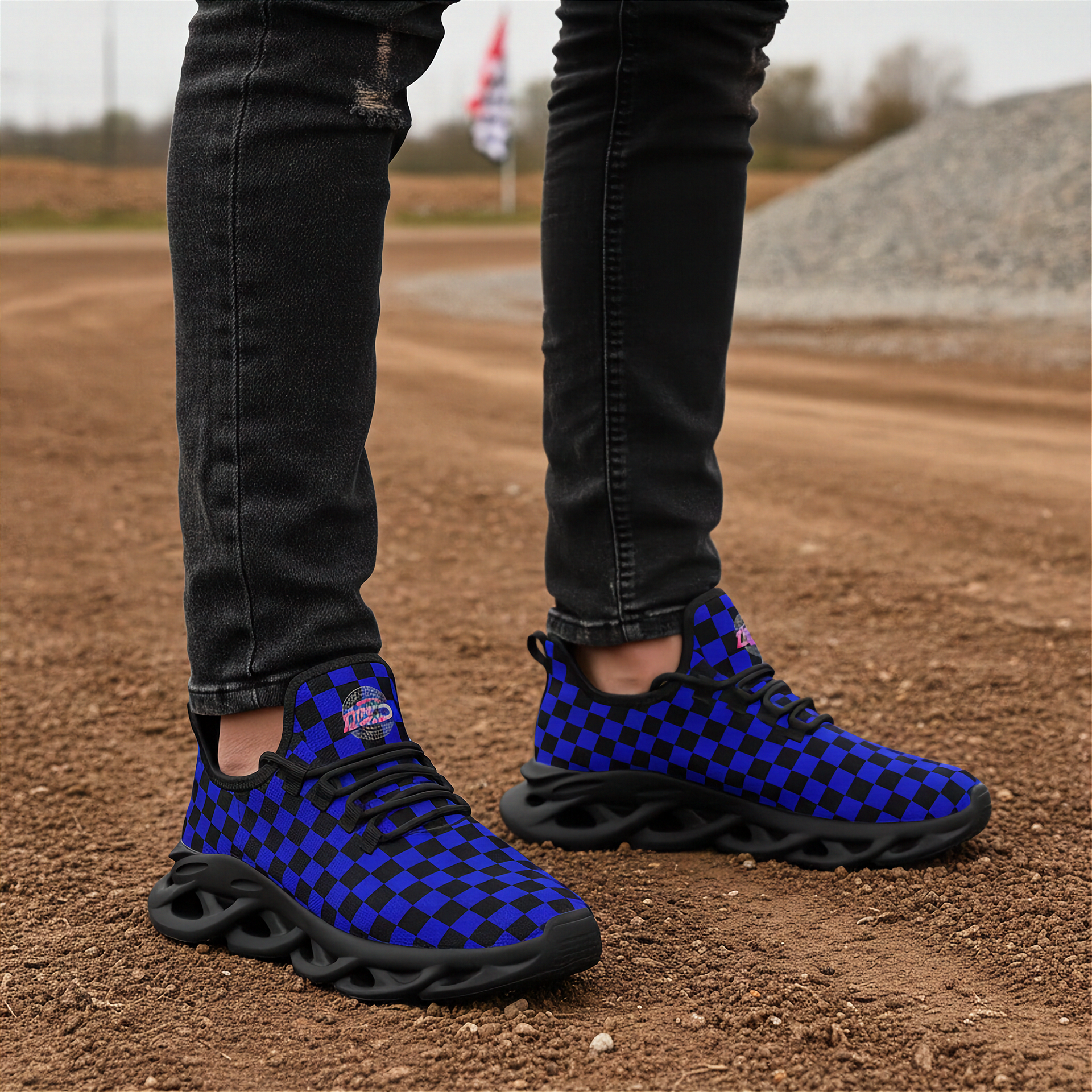 Blue and black checkered shoes worn on a dirt surface