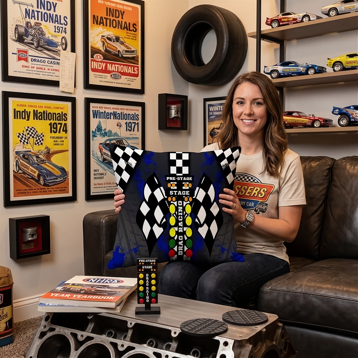 a Woman sitting on a sofa in a themed drag racing living room holding a drag racing pillow with big DRAG RACING Christmas tree