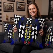 a Woman sitting on a sofa in a themed drag racing room holding a drag racing pillow with big DRAG RACING Christmas tree
