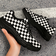 Black and white checkered sneakers on a gray concrete surface