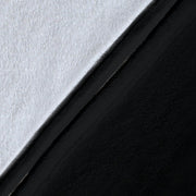Close-up of the blanket’s white microfleece backing, black printed surface, and stitched black edge.
