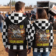 Couple wearing matching personalized sprint car sherpa jackets at a dirt track, showing checkered backs with car, name, and number.
