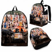 A backpack shown from multiple angles on a plain white background, featuring a printed racing scene with a black demolition derby race car, orange accents, and a crowd of spectators.