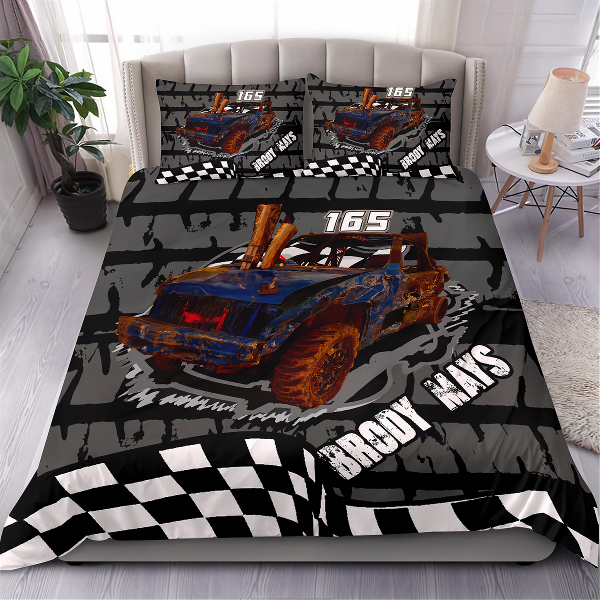A racing-themed bedding set displayed on a bed in a bedroom setting, featuring a duvet cover and two matching pillowcases with a blue and orange rusted race car, checkered flags, and the text '165 BRODY RAYS'.