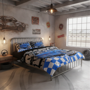 A bed dressed in a blue, black, and white racing-themed bedding set with a checkered blanket and patterned pillows, placed in a rustic industrial-style bedroom with racing wall decals and a metal bed frame.