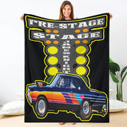 A woman holding a custom blanket with a drag racing theme, featuring a colorful image of a car on a black background with the text 'PRE-STAGE JAKEENKO'.
