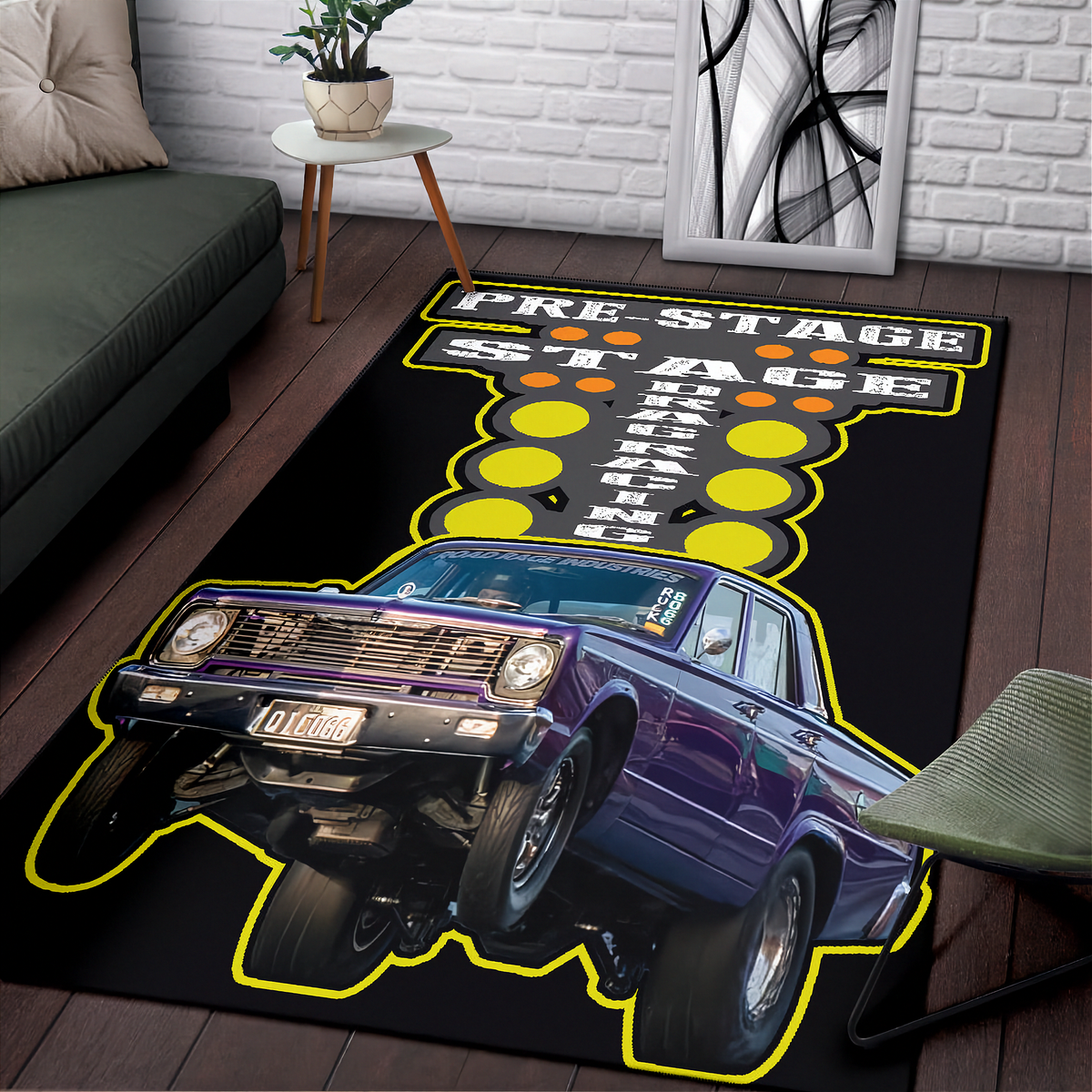 A rectangular area rug featuring a purple classic muscle car and the words 'PRE-STAGE STAGE FIGHT' in bold yellow, black, and white lettering, shown on a dark wood floor in a living room setting.