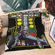 Blanket with racing design featuring a traffic light and motorcycle on a couch.