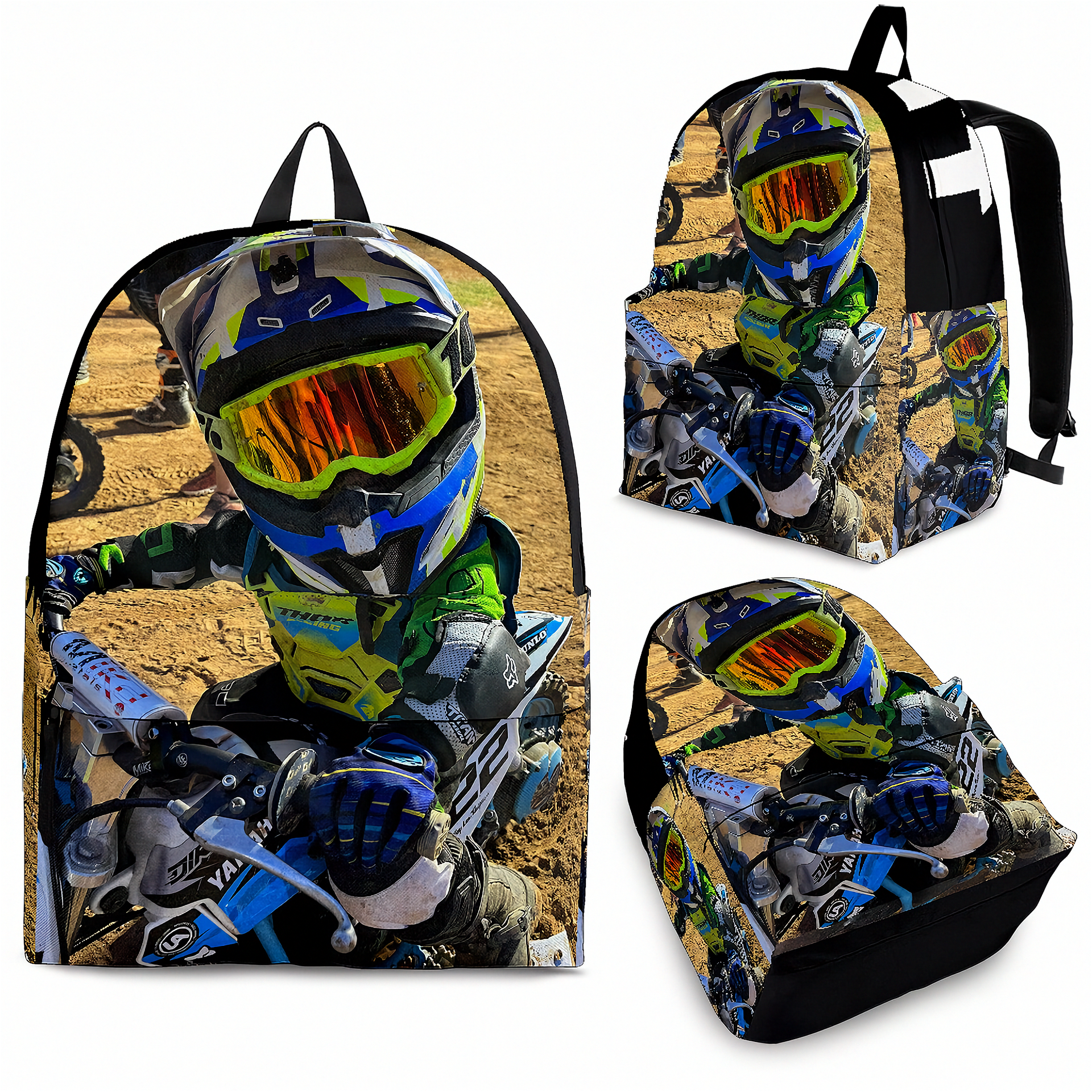 A backpack shown from multiple angles on a white background, featuring a full-color printed graphic of a motocross rider in a helmet and suit riding a dirt bike on a sandy track.