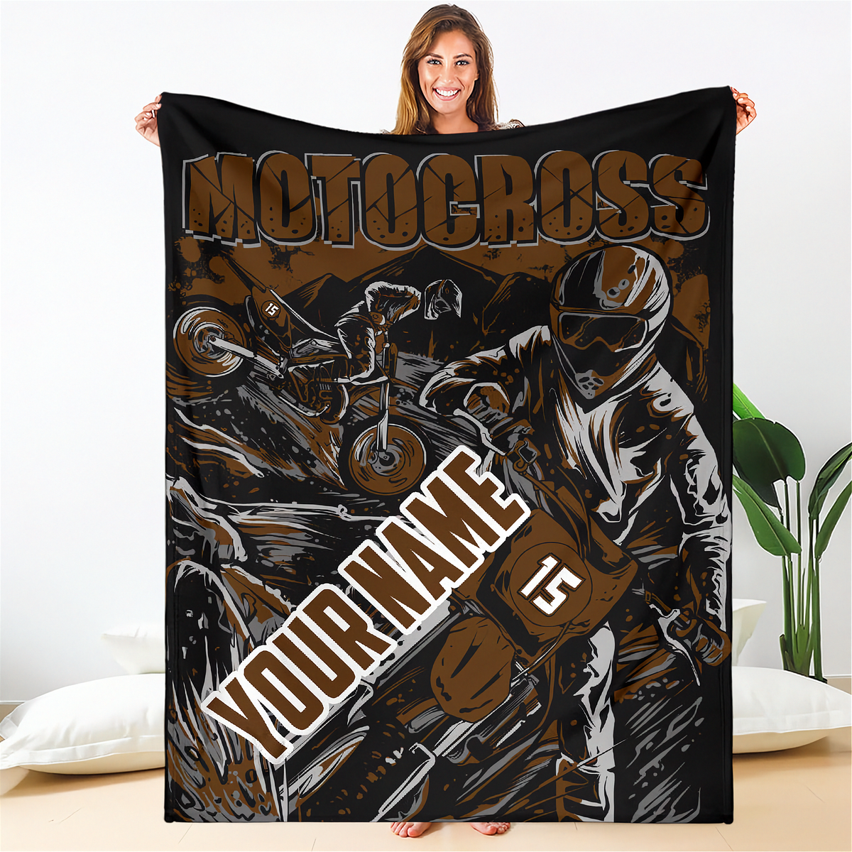 Woman holding a brown and black custom motocross blanket with dirt bike rider artwork, “Your Name” placeholder and sample number 15.