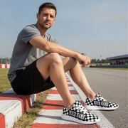 Man sitting on a race track wearing checkered shoes with 'Your Name' text.