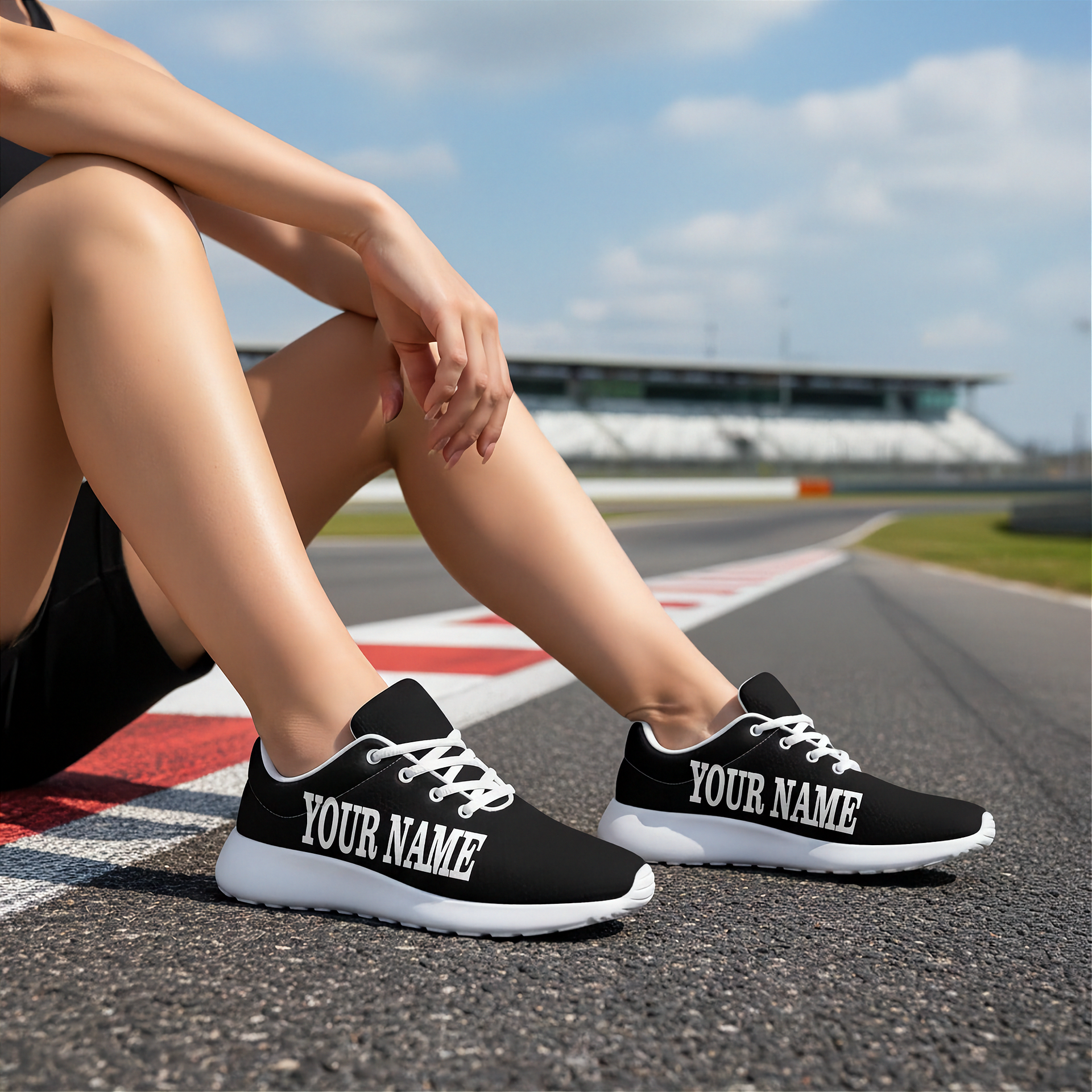 Person wearing black sneakers with 'YOUR NAME' text on a race track.
