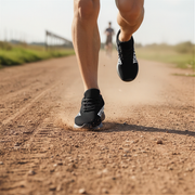 Person running on a dirt path with black custom running shoes