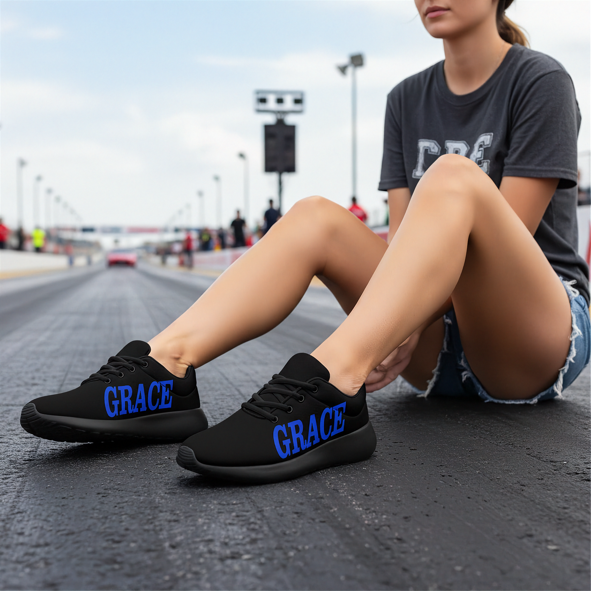 Person wearing black sneakers with 'GRACE' branding on a race track.