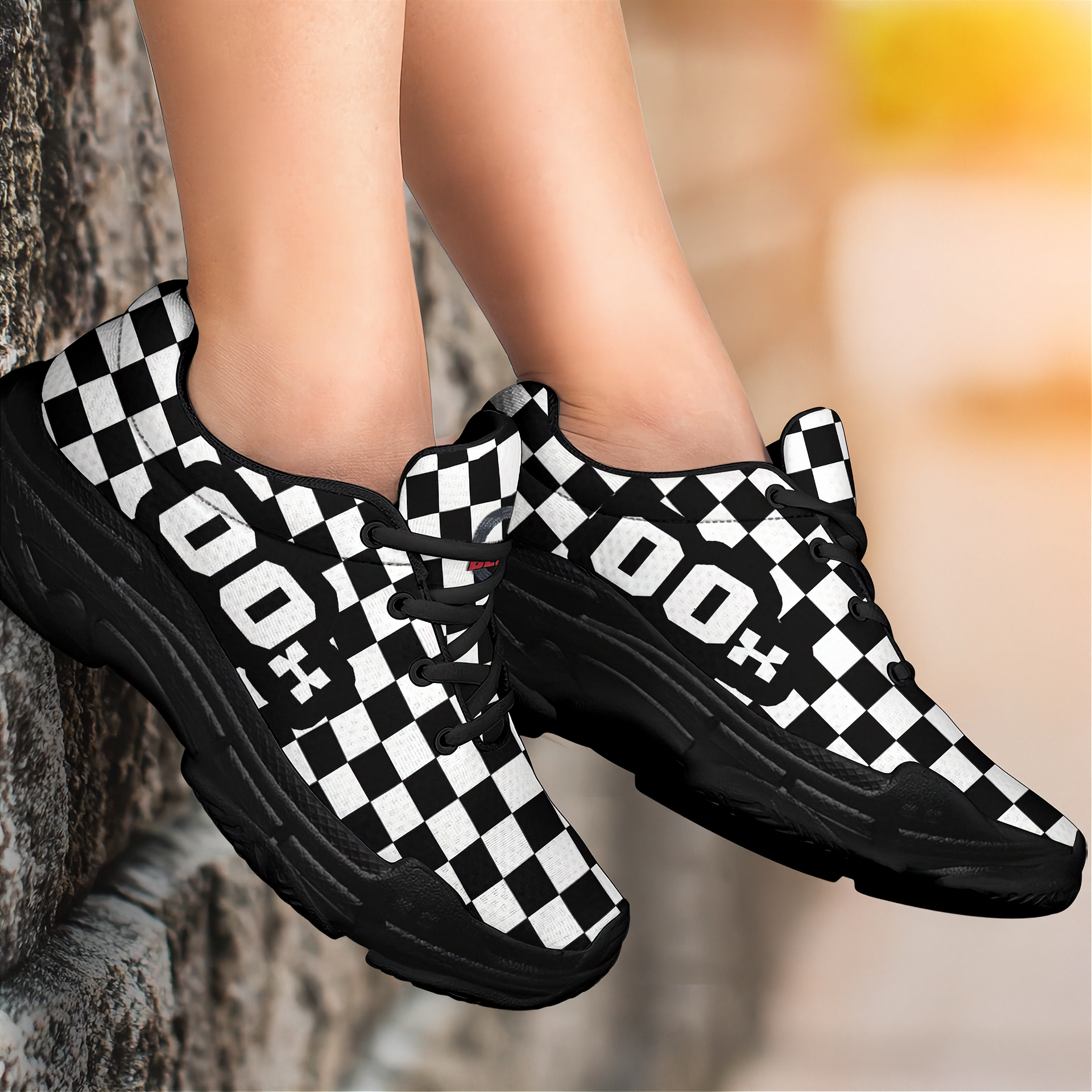 Black and white checkered sneakers worn by a person against a blurred natural background