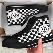 Black and white checkered high-top sneakers with number 24 design, held by a hand.
