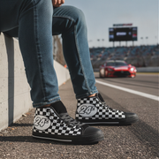 Person wearing checkered shoes with number 24 on a race track.