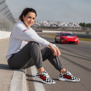 Woman sitting on a race track with a red car in the background