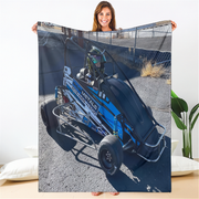 Person holding a blanket with a blue go-kart design on a white background