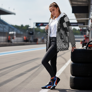 Woman standing next to tires on a race track wearing a custom sherpa jacket