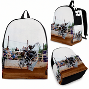 A backpack shown from multiple angles on a white background, featuring a printed graphic of a rodeo scene with a cowboy on a bucking bronco. The backpack has a white body, black straps and trim, and a brown dirt-ground lower section in the print.