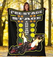 woman holding a large blanket with a dragster graphic and text in a forest setting