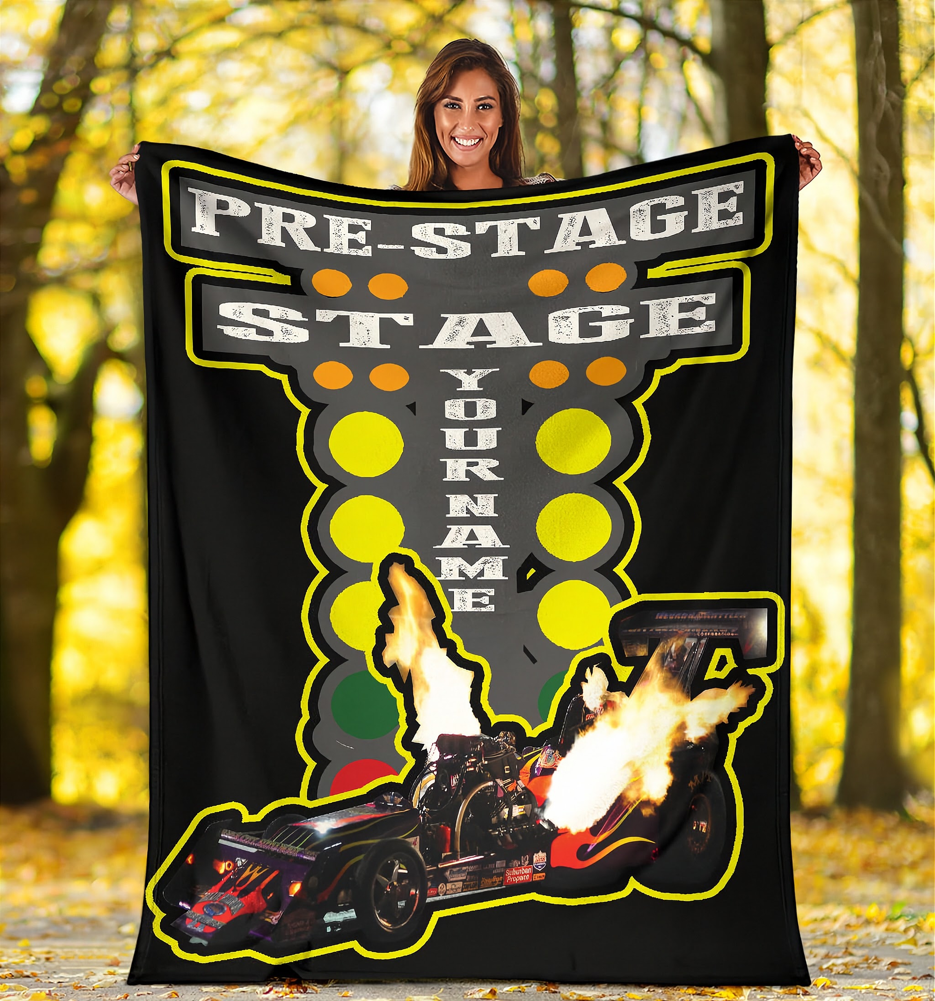 woman holding a large blanket with a dragster graphic and text in a forest setting