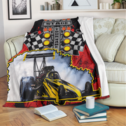 Custom dragster photo and name blanket draped over a cream sofa, with white microfleece backing folded outward.