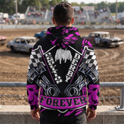 A man stands with his back to the camera wearing a black hoodie with a highly detailed, colorful racing graphic print featuring pink, white, and black. The background shows a dirt track with race cars and spectators in the stands.