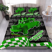 A bed dressed in a green and black racing-themed bedding set featuring a large neon green off-road car graphic, checkered flag patterns, and the words 'DEFORMATION DERBY' on the comforter and matching pillowcases, shown in a styled bedroom setting.