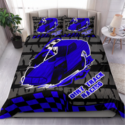A racing-themed bedding set featuring a duvet cover and two pillowcases with a black and red checkered pattern, yellow lights, and a large illustrated race car on a bed in a bedroom.