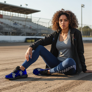 Woman sitting on a race track wearing athletic checkered dirt racing shoes