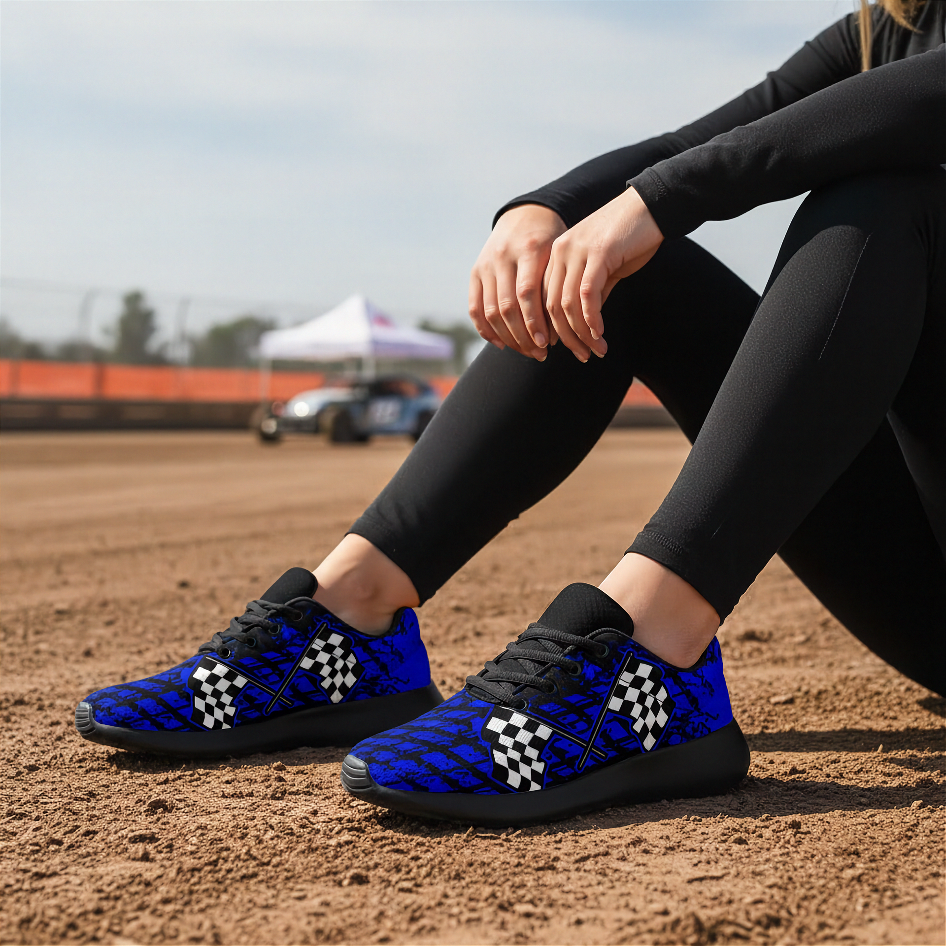Woman sitting at a dirt track wearing a Dirt Racing Blue Muddy Flag Sneakers 