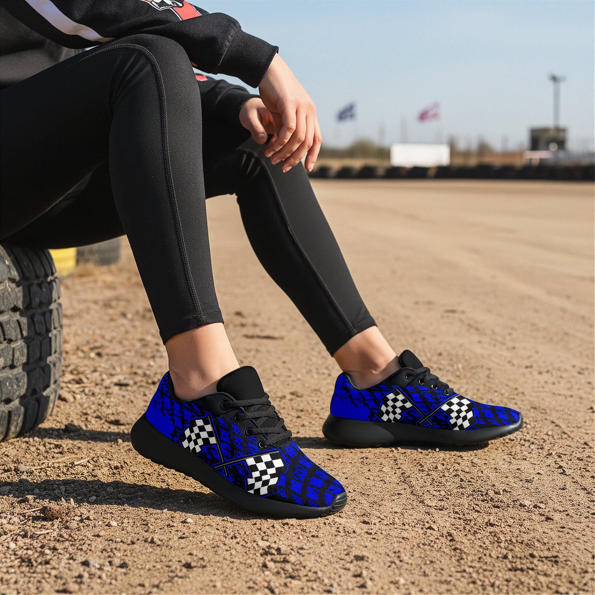 Woman wearing blue and black checkered sneakers sitting on a tire outdoors.