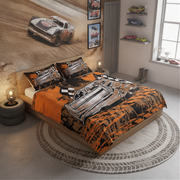 A racing-themed bedding set featuring an orange, black, and white dirt-track late model car print, styled on a wooden bed in a modern, light-filled bedroom with a matching wall mural.