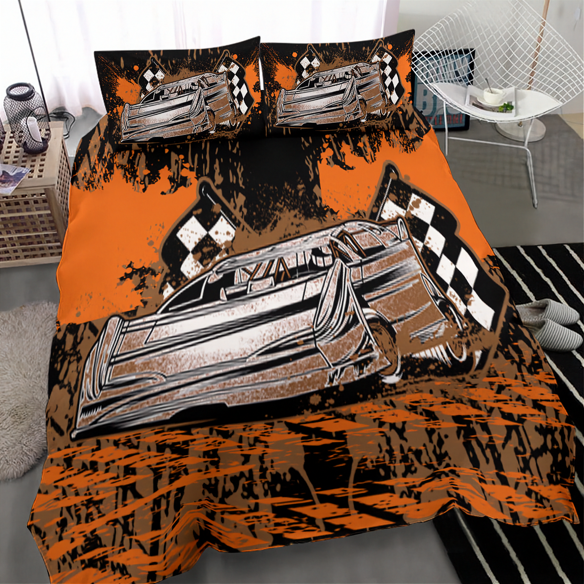 A racing-themed bedding set featuring a duvet cover and two matching pillowcases with a stylized graphic of a classic race car and checkered flags on an orange and black splattered background, shown on a bed in a modern bedroom setting.