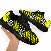 Black and yellow checkered sneakers held by a hand on a white background