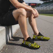 man sitting at a race track wearing a yellow checkered shoes