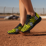 Woman wearing bright yellow and black checkered sneakers on a dirt track.