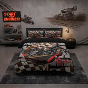 A themed kids' bedroom featuring a bed dressed in a dirt track racing bedding set with a checkered pattern and a hot rod graphic. The room is styled with racing decals on the wall, toy cars on shelves, and a neon sign that reads 'START YOUR ENGINES!'.